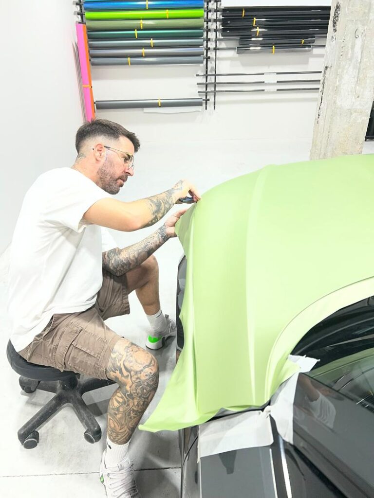 Car wrapping verde mate durante la instalación en el taller